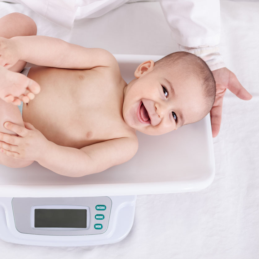 Measuring smiling beautiful comfortable little baby